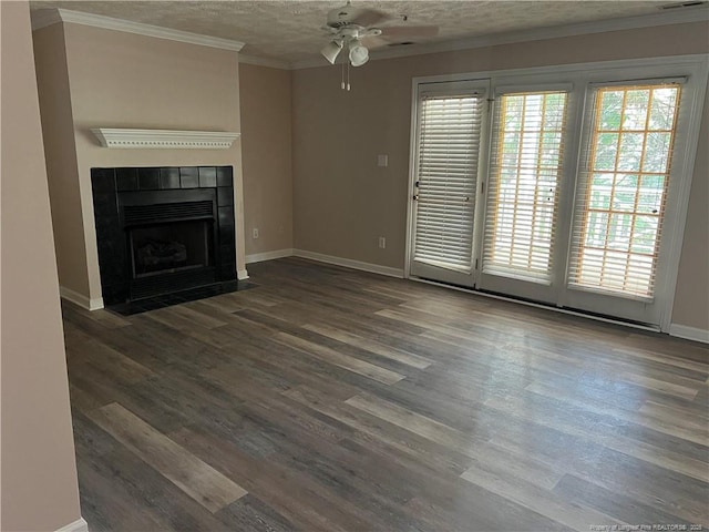 unfurnished living room featuring ceiling fan, baseboards, wood finished floors, a tile fireplace, and a textured ceiling