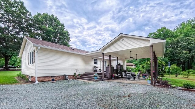 rear view of property with ceiling fan, crawl space, a patio area, and a shingled roof