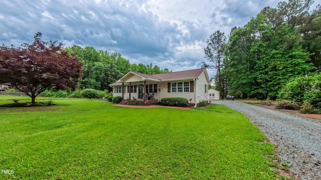 single story home featuring covered porch, a front yard, and driveway