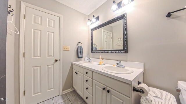 bathroom featuring double vanity and toilet