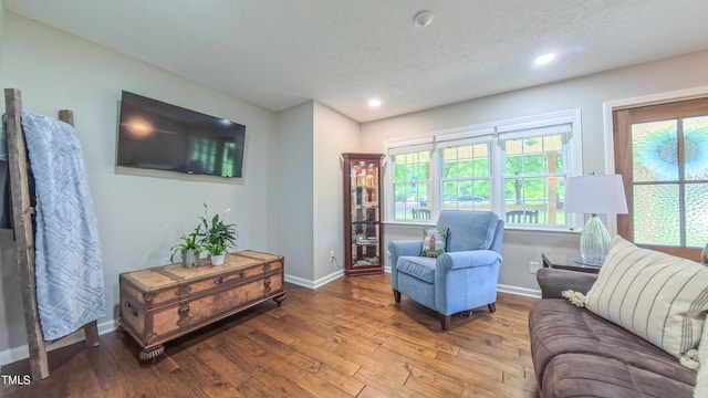 living area featuring hardwood / wood-style flooring, baseboards, recessed lighting, and a textured ceiling