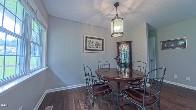 dining room featuring healthy amount of natural light, dark wood-style floors, and baseboards