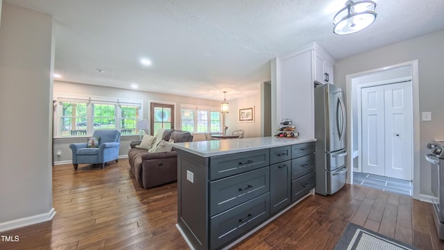 kitchen with freestanding refrigerator, white cabinets, dark wood-style flooring, light countertops, and gray cabinetry