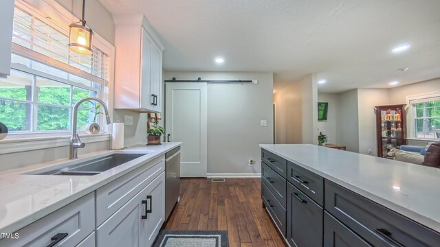 kitchen featuring a sink, dark wood finished floors, a barn door, pendant lighting, and recessed lighting
