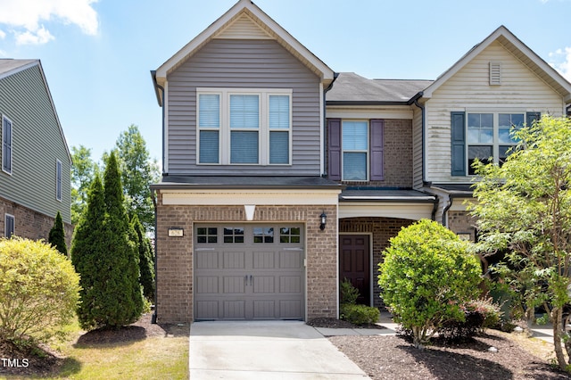 view of front of property with brick siding, an attached garage, and driveway