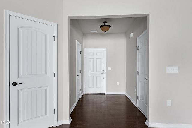 corridor with dark wood finished floors and baseboards