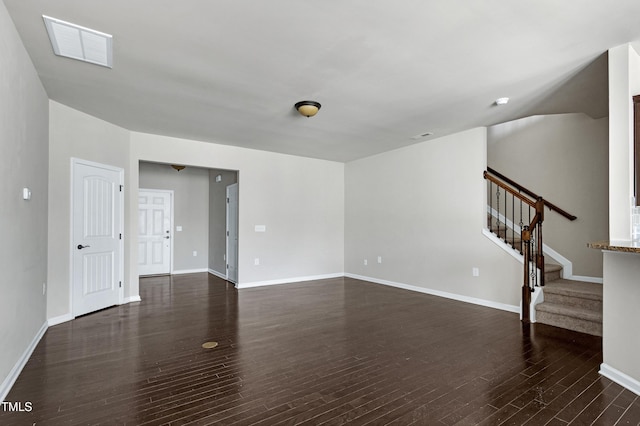 unfurnished living room with dark wood-type flooring, stairway, and baseboards