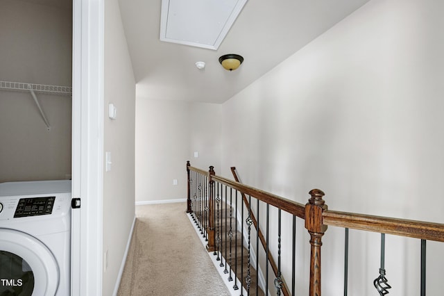hallway featuring washer / dryer, an upstairs landing, carpet floors, attic access, and baseboards