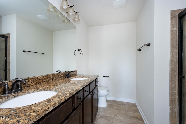full bath with toilet, a shower stall, baseboards, and double vanity