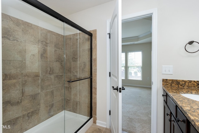 full bath featuring a stall shower, baseboards, and vanity