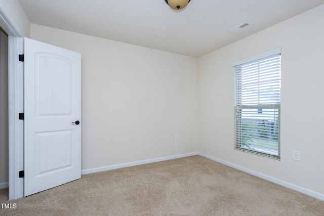 empty room featuring carpet and baseboards