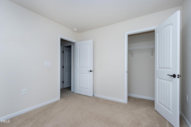 unfurnished bedroom with carpet flooring, baseboards, and a closet