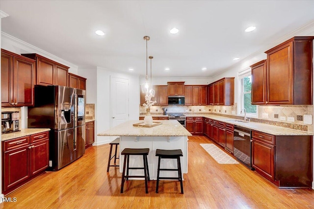 kitchen featuring stainless steel appliances, light wood-type flooring, a kitchen bar, tasteful backsplash, and a kitchen island