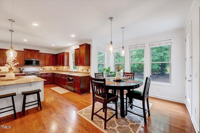 dining space featuring ornamental molding, light wood-style flooring, baseboards, and recessed lighting