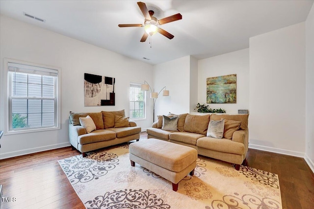 living area featuring a ceiling fan, wood finished floors, and baseboards