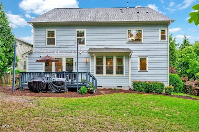rear view of property with a yard, a deck, and crawl space