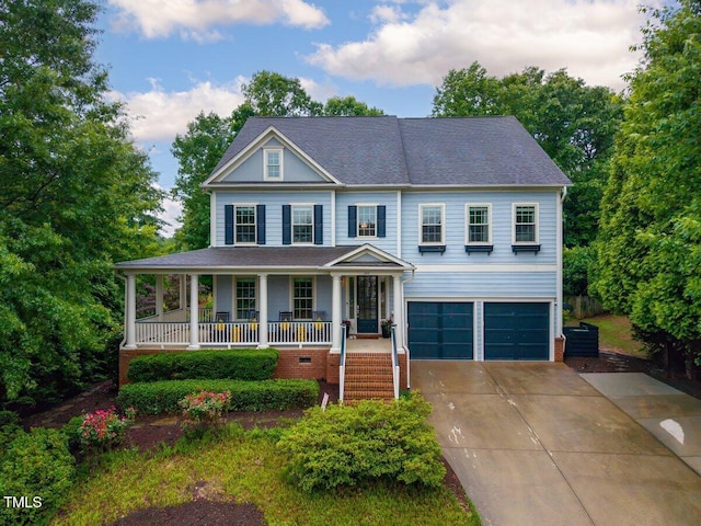view of front of home featuring covered porch, an attached garage, driveway, and roof with shingles