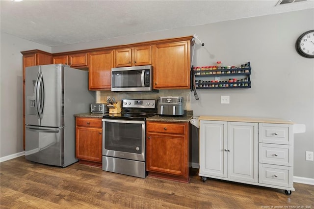 1624 Citation Ct, Parkton, NC 28371 - kitchen featuring stainless steel appliances, brown cabinetry, baseboards, and dark wood-style floors