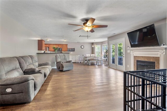 1624 Citation Ct, Parkton, NC 28371 - living room featuring wood finished floors, ceiling fan, a fireplace, and a textured ceiling