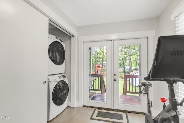 clothes washing area with stacked washer and clothes dryer and french doors