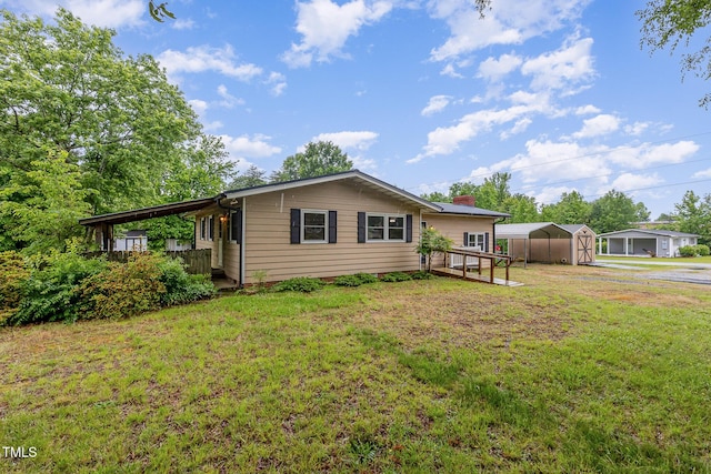view of front of home featuring dirt driveway, a detached carport, a front lawn, and an outbuilding
