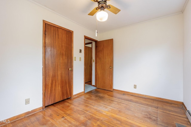 unfurnished bedroom featuring wood finished floors, baseboards, crown molding, a closet, and a ceiling fan