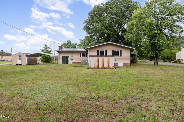 rear view of property with a detached carport, a lawn, and cooling unit