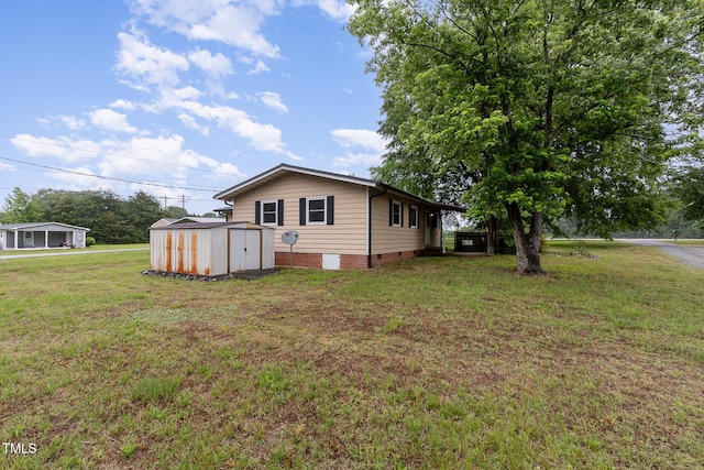 view of front of property featuring a storage shed, a front yard, an outdoor structure, and crawl space