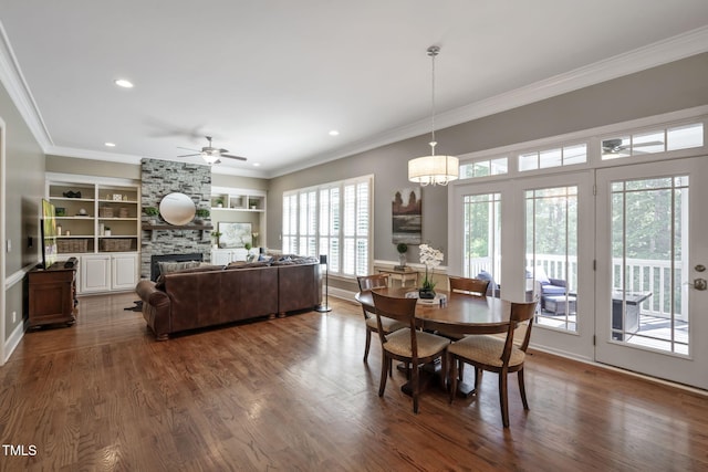 117 Synandra Ln, Holly Springs, NC 27540 - dining space featuring built in shelves, a fireplace, ornamental molding, dark wood-style floors, and a ceiling fan