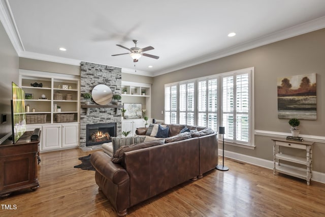 117 Synandra Ln, Holly Springs, NC 27540 - living area featuring ceiling fan, a stone fireplace, ornamental molding, wood finished floors, and baseboards