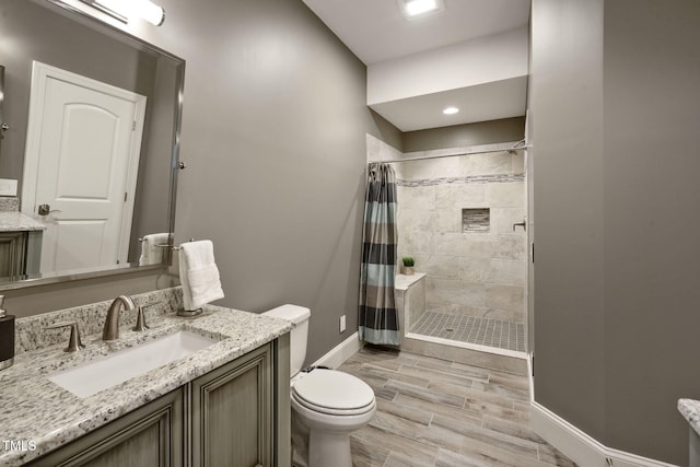 117 Synandra Ln, Holly Springs, NC 27540 - bathroom with vanity, a tile shower, baseboards, toilet, and wood finished floors