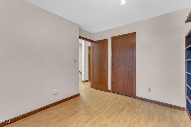 unfurnished bedroom featuring light wood-style flooring and baseboards