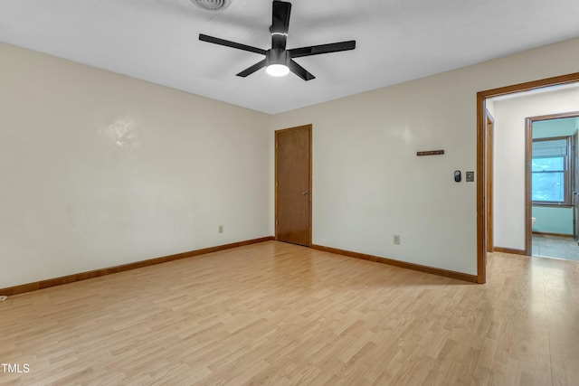 spare room with light wood-style flooring, a ceiling fan, and baseboards