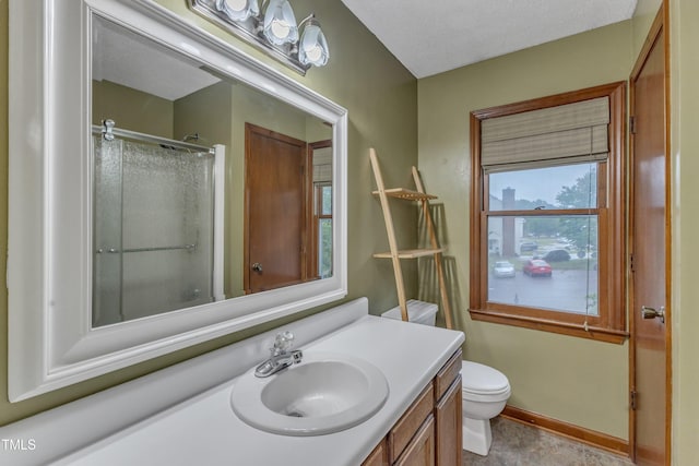 bathroom featuring an enclosed shower, vanity, toilet, and baseboards