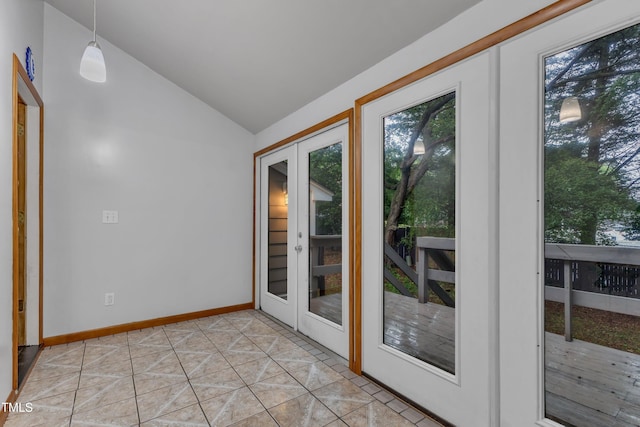 doorway to outside featuring healthy amount of natural light, vaulted ceiling, and baseboards