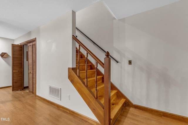 staircase with wood finished floors and baseboards