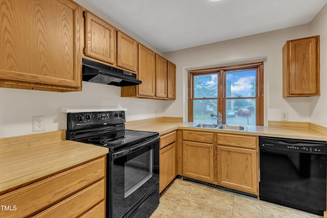 kitchen with black appliances, under cabinet range hood, a sink, and light countertops