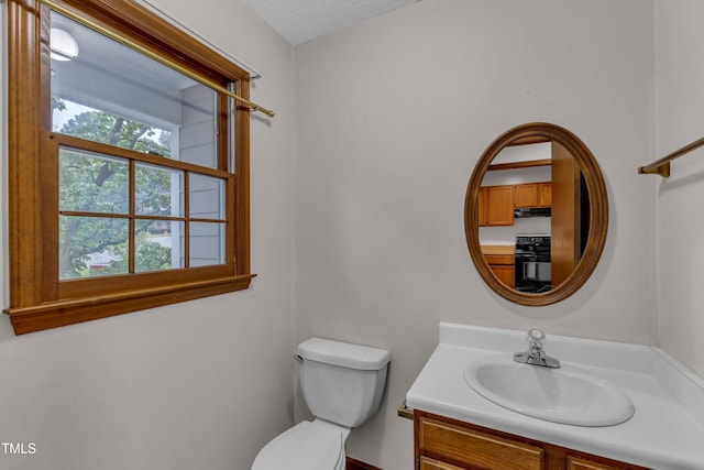 bathroom featuring vanity, toilet, and a textured ceiling