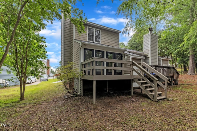 rear view of house with a deck, stairs, and a chimney