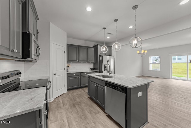 19 Willow Green Dr, Clayton, NC 27527 - kitchen with appliances with stainless steel finishes, a sink, open floor plan, light wood-style floors, and a center island with sink