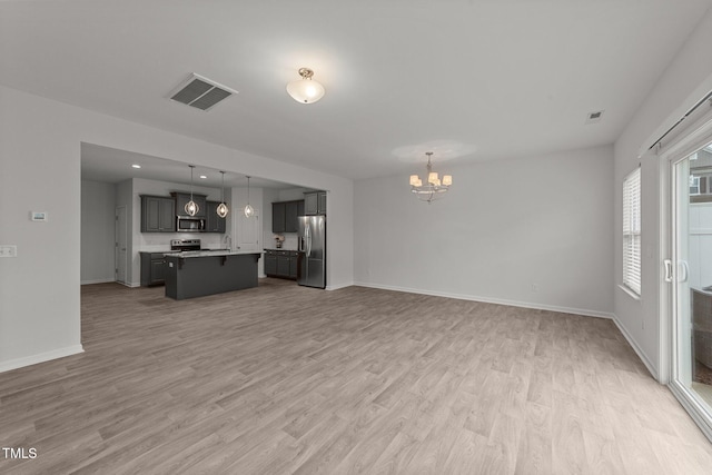 19 Willow Green Dr, Clayton, NC 27527 - unfurnished living room featuring a chandelier, light wood-type flooring, and baseboards