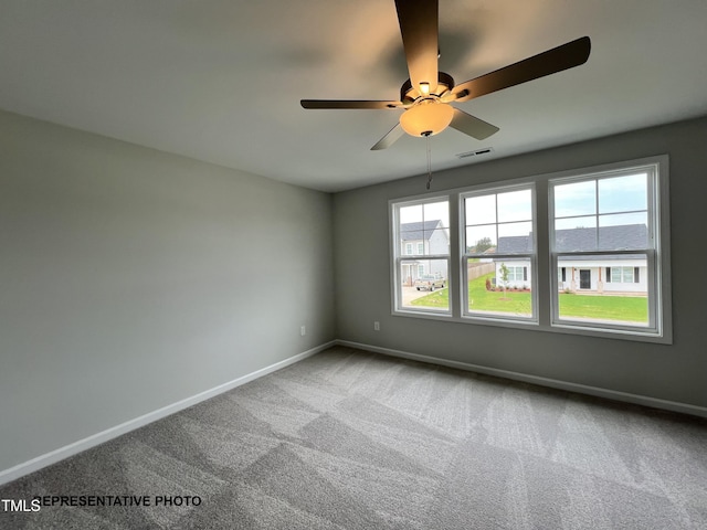 spare room with carpet floors, baseboards, and a ceiling fan
