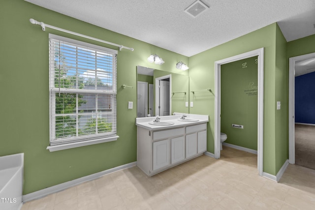 3705 Rivermist Dr, Raleigh, NC 27610 - bathroom with toilet, double vanity, baseboards, and a textured ceiling