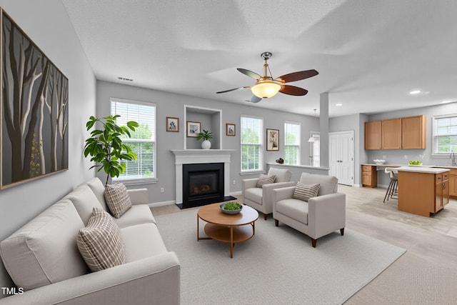 3705 Rivermist Dr, Raleigh, NC 27610 - living room featuring light carpet, a fireplace with flush hearth, a ceiling fan, recessed lighting, and baseboards