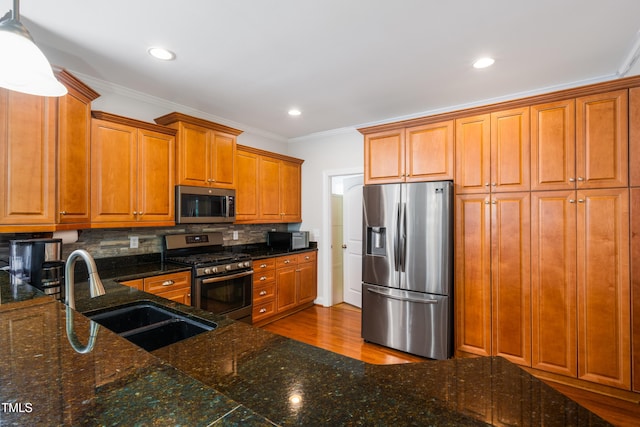1218 Crystalwater Dr, Fuquay Varina, NC 27526 - kitchen featuring stainless steel appliances, a sink, brown cabinetry, ornamental molding, and tasteful backsplash