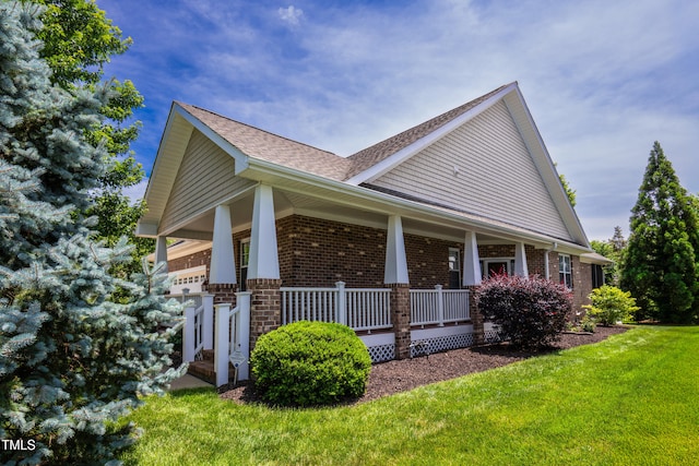 1218 Crystalwater Dr, Fuquay Varina, NC 27526 - view of property exterior featuring a porch, brick siding, a lawn, and roof with shingles