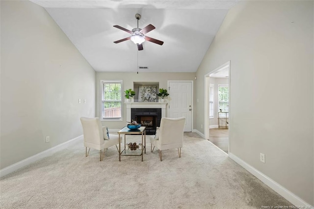 sitting room with vaulted ceiling, a fireplace, baseboards, and healthy amount of natural light