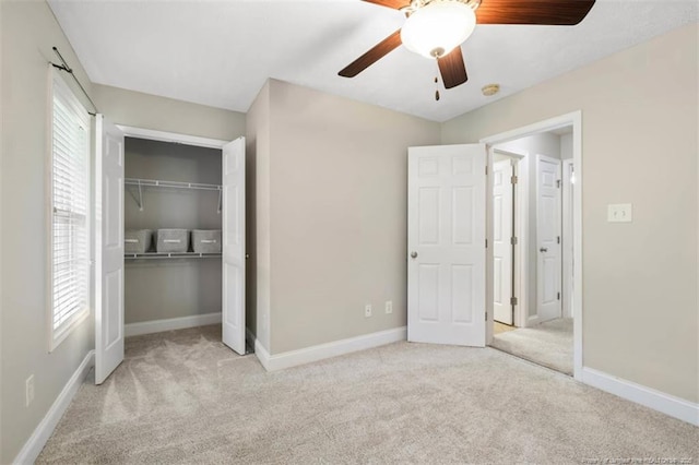 unfurnished bedroom with carpet flooring, a closet, baseboards, and a ceiling fan