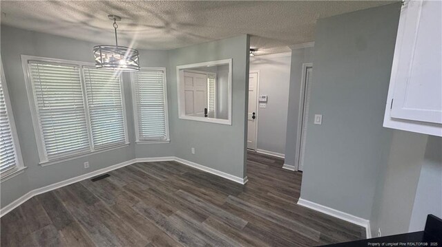 303 Nash Rd, Saint Pauls, NC 28384 - unfurnished dining area featuring a chandelier, dark wood-type flooring, a textured ceiling, and baseboards