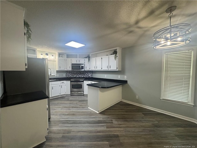 303 Nash Rd, Saint Pauls, NC 28384 - kitchen with appliances with stainless steel finishes, a peninsula, white cabinets, dark countertops, and dark wood finished floors
